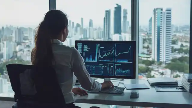 Una profesional se enfoca en monitores con gráficos financieros en una oficina con vista a rascacielos e investiga cómo ser contador público.